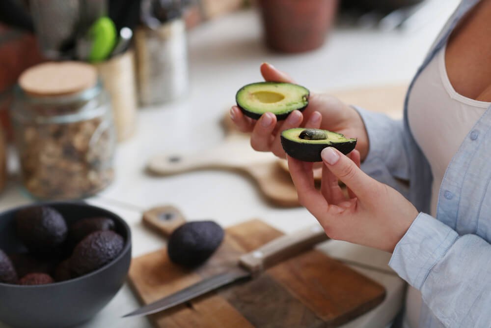 Woman cutting open a magnesium rich avocado
