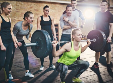 Woman squatting low with all her friends cheering