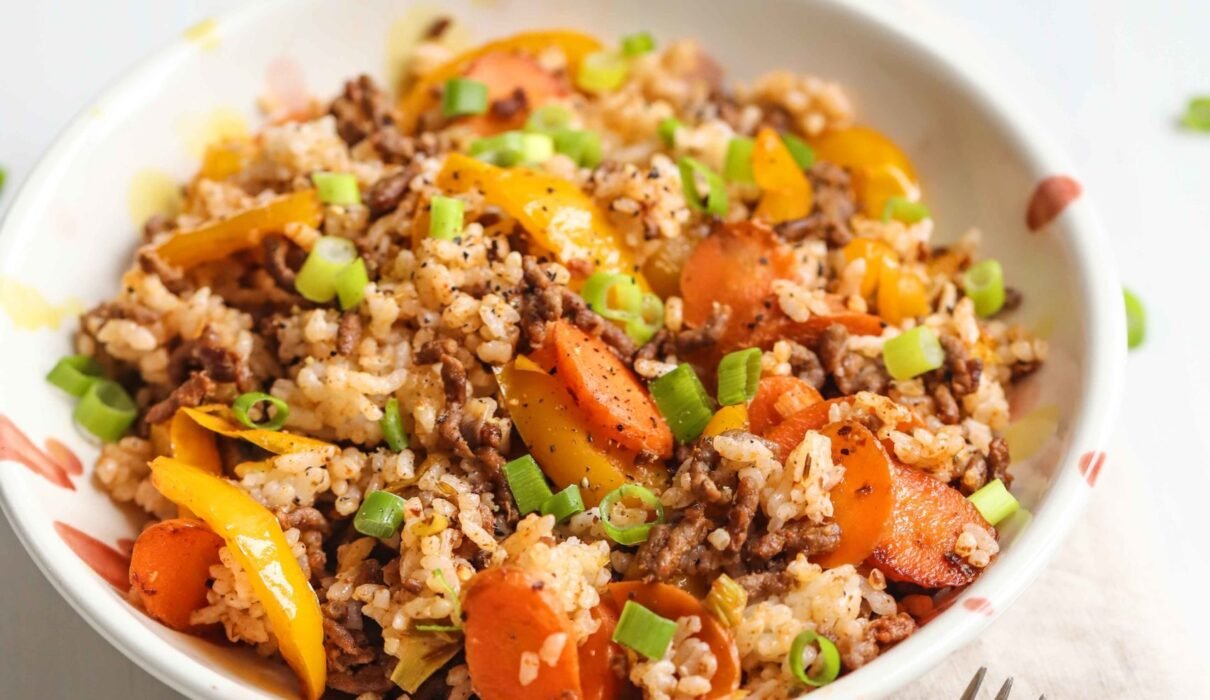 A bowl of cajun beef with veggies and rice