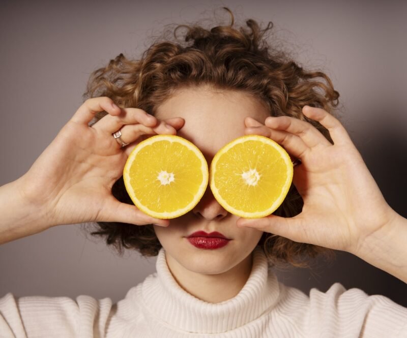 Woman with sliced lemons to detox on her eyes