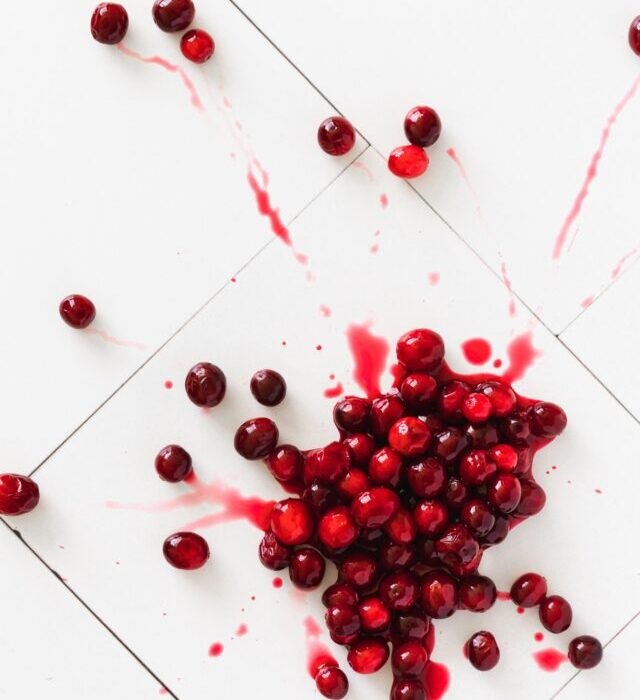 Cranberries splattered on a white tiled floor