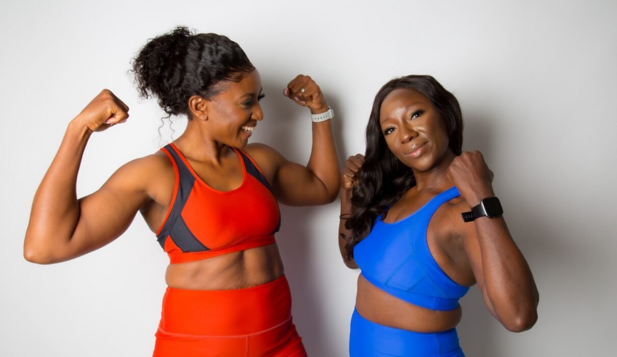 Two women happy and flexing their muscular arms