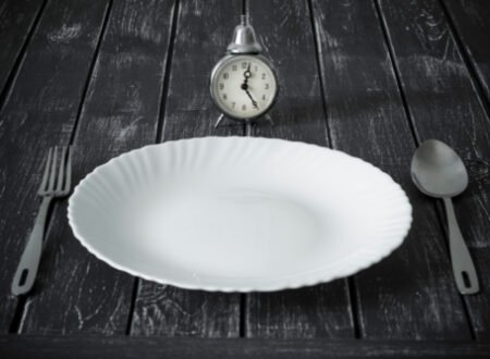 Clock and an empty plate with cutlery