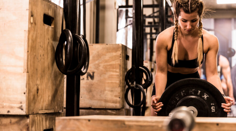 Woman preparing plates on a bar to lift heavy