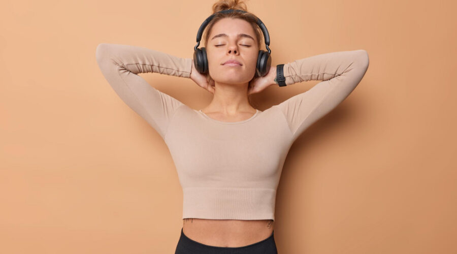 Fit woman with headphones tired after a hard workout