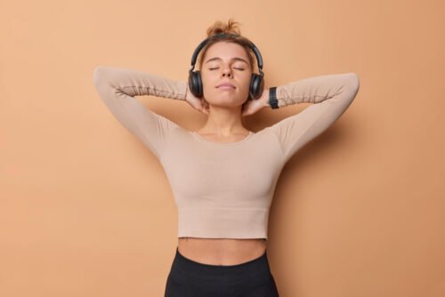 Fit woman with headphones tired after a hard workout
