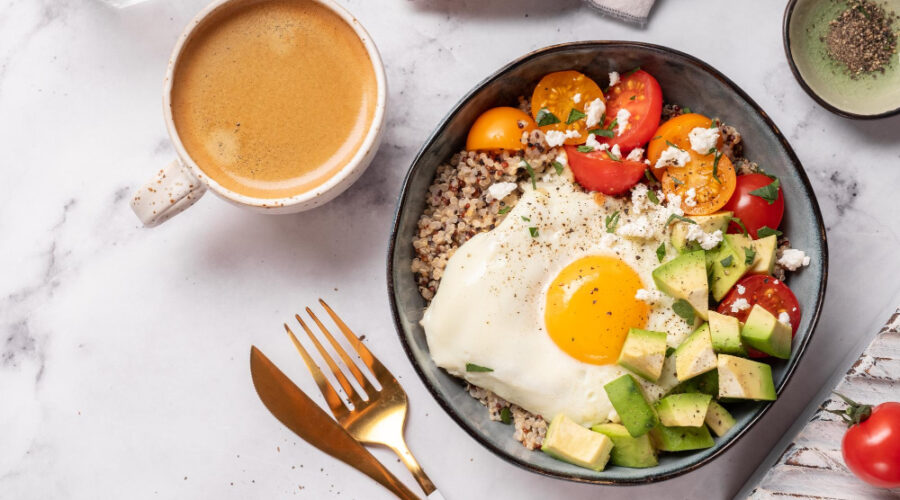 Healthy breakfast meal of avocado, quinoa and egg with a coffee