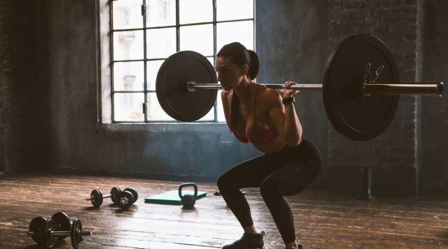 Woman squatting with a heavy bar