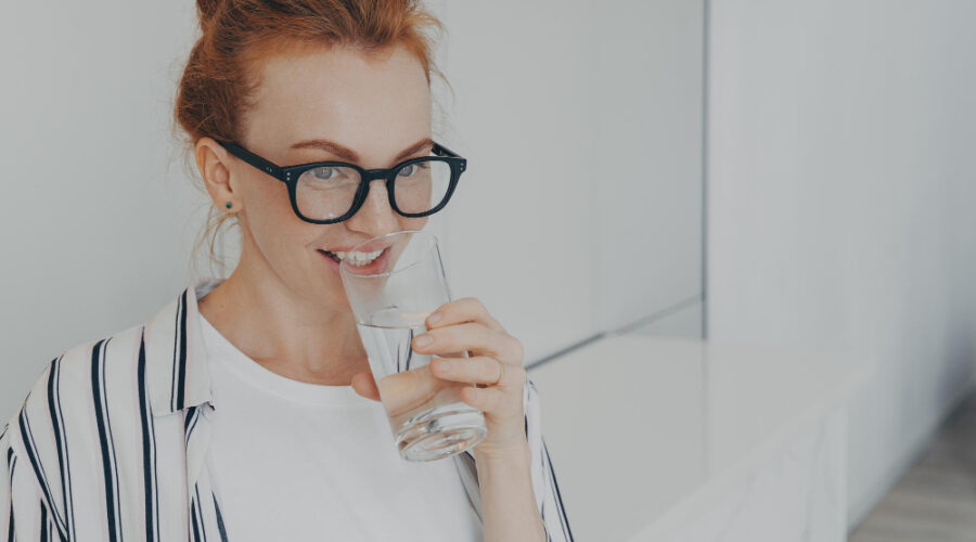 Woman with glasses drinking water