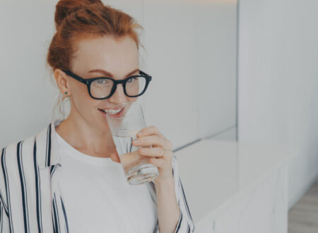 Woman with glasses drinking water