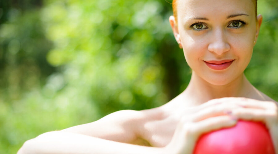 Image of a pretty lady holding a red heart or ball