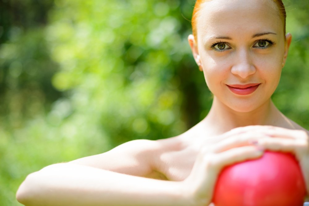 Image of a pretty lady holding a red heart or ball