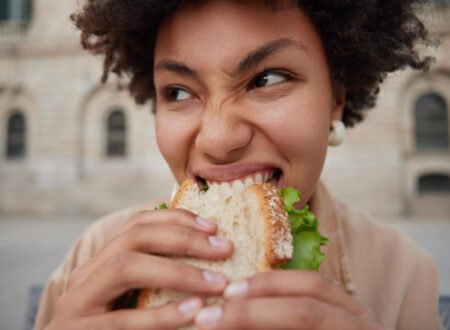 Woman hungry and taking a bite out of a delicious sandwich