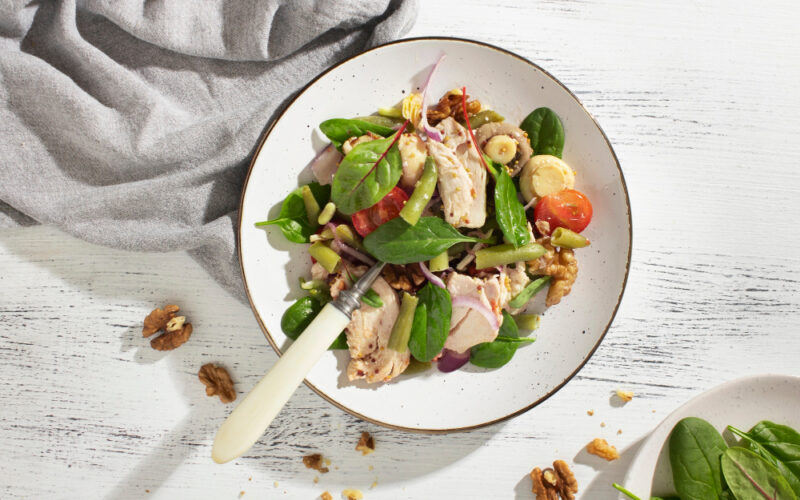 A plate with tuna and veggies, including nuts