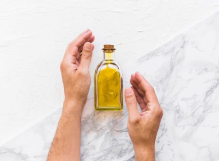 Small bottle of oilve oil in between someones hands