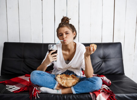 Woman on the couch eating some junk food