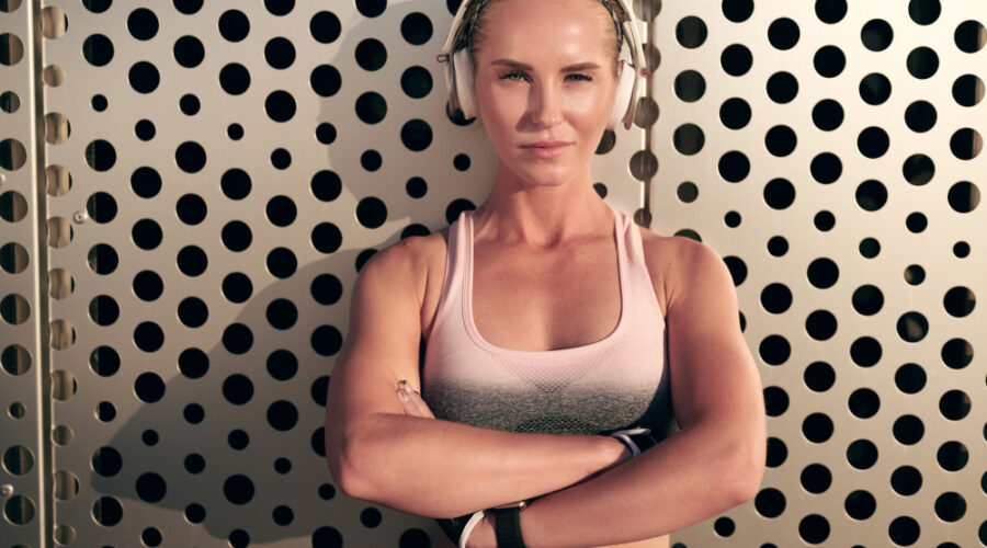 Woman crossing hands who's strong and with headphones