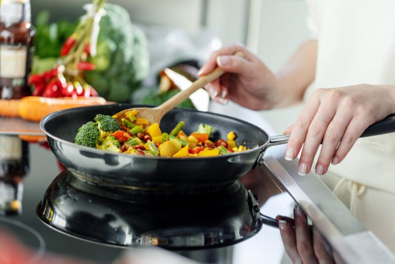 woman-cooking-vegetables-pan