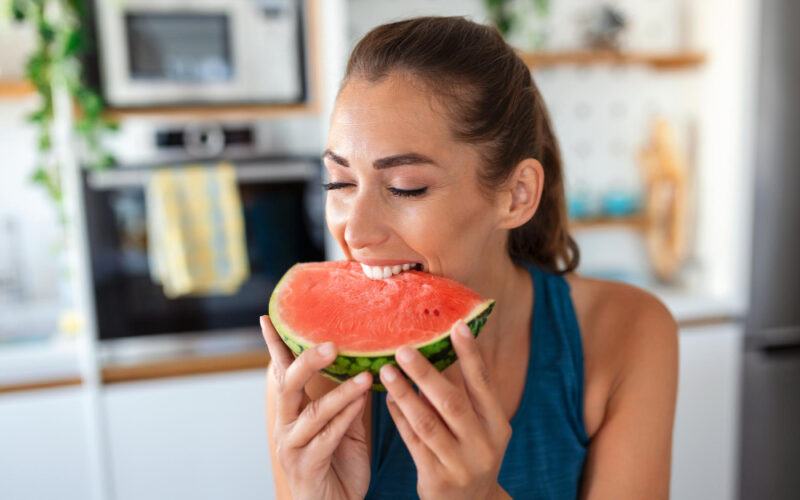 Woman eating a delicious slice of watermellon