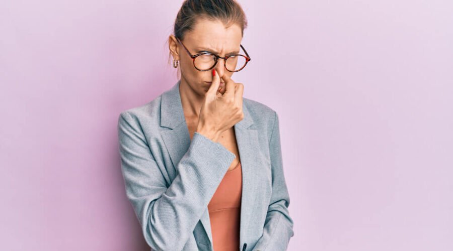 Woman holding her nose because of a very bad fart smell!